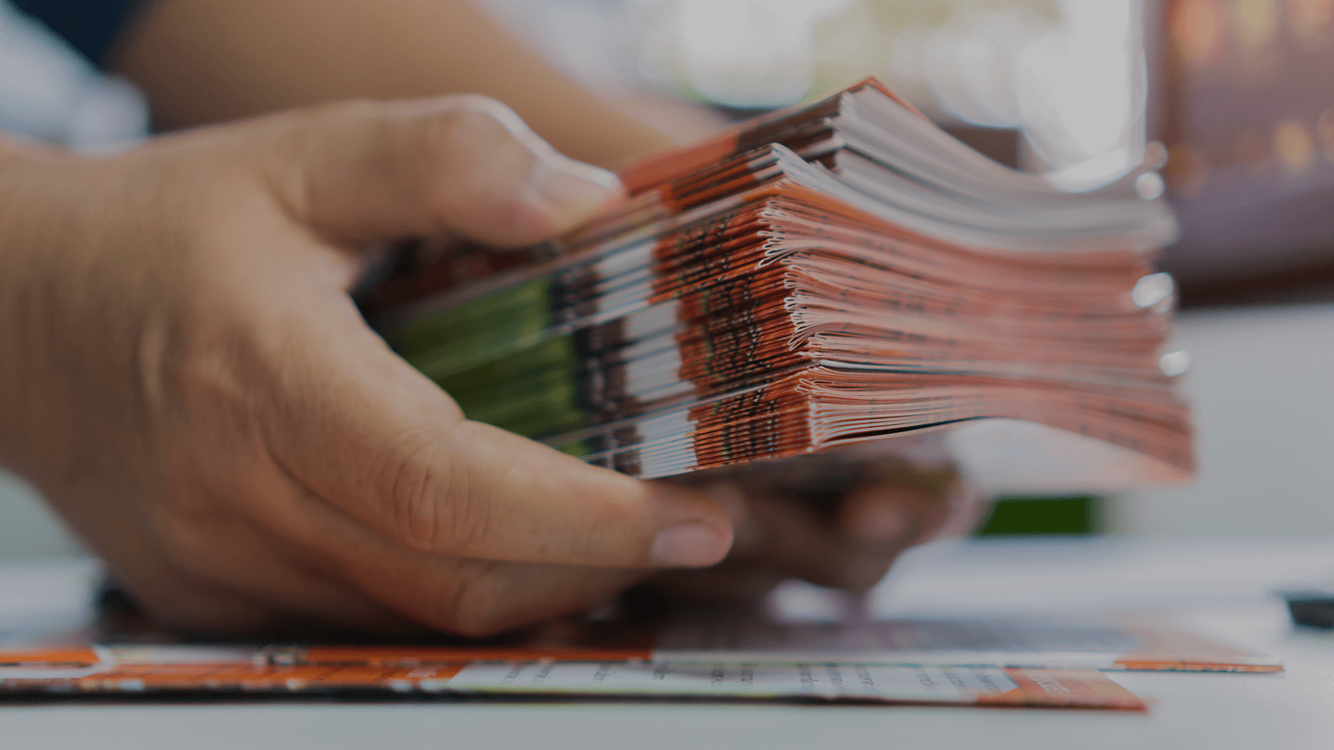 Hands holding copies of web-to-print materials